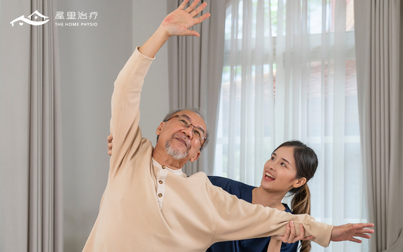 A nurse conducting home based physiotherapy for an elderly man