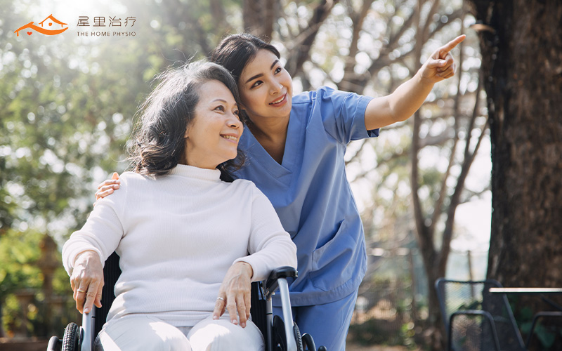 elderly woman in a wheelchair with her caregiver at the park