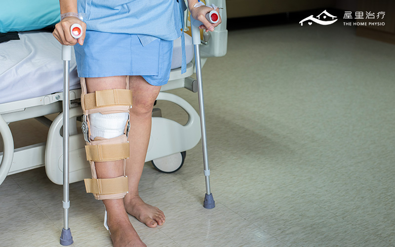 patient in knee brace standing with crutches