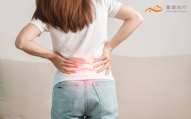 woman holding her lower back