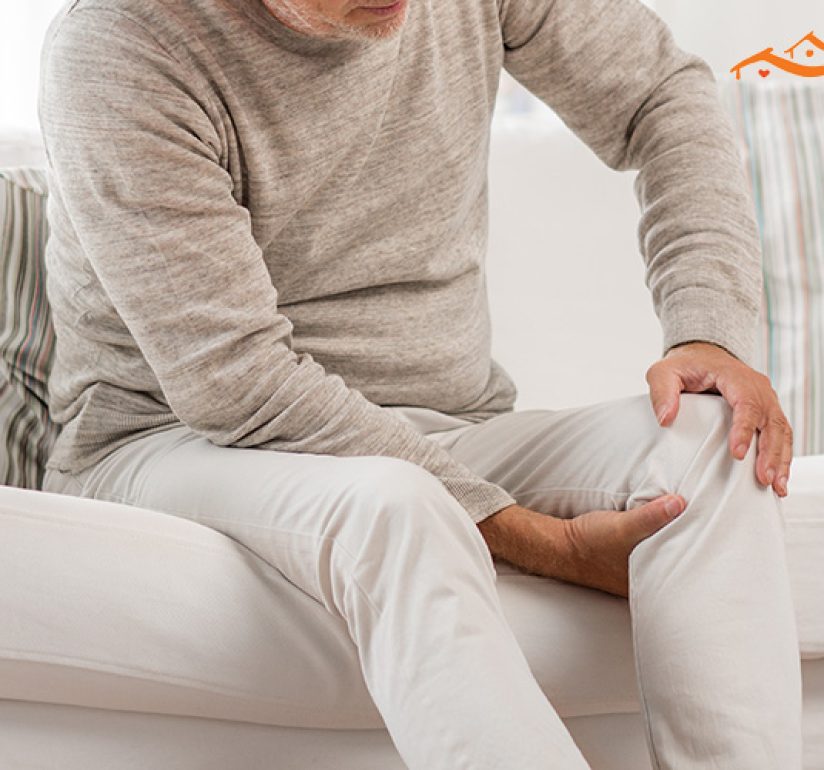 elderly man holding his knee in pain